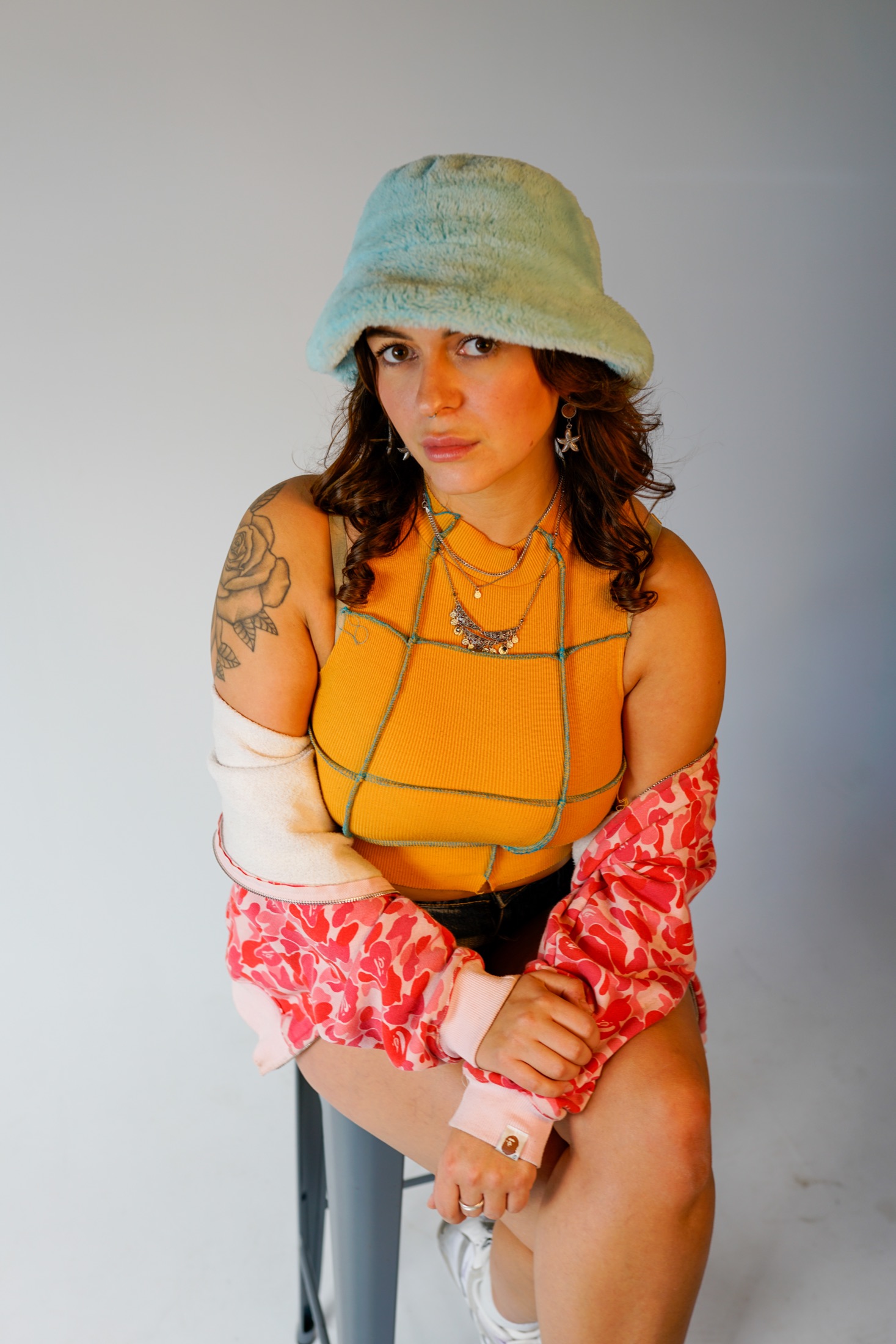 Leoa wearing a pale blue hat and orange top